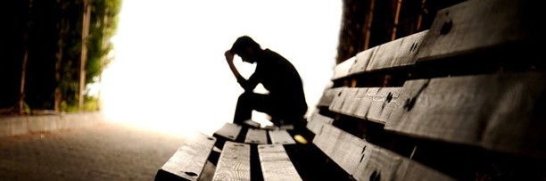 man at end of bench thinking